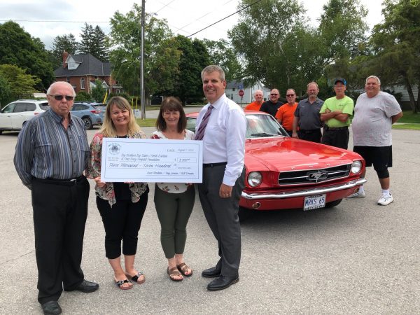 cheque presentation infront of red car